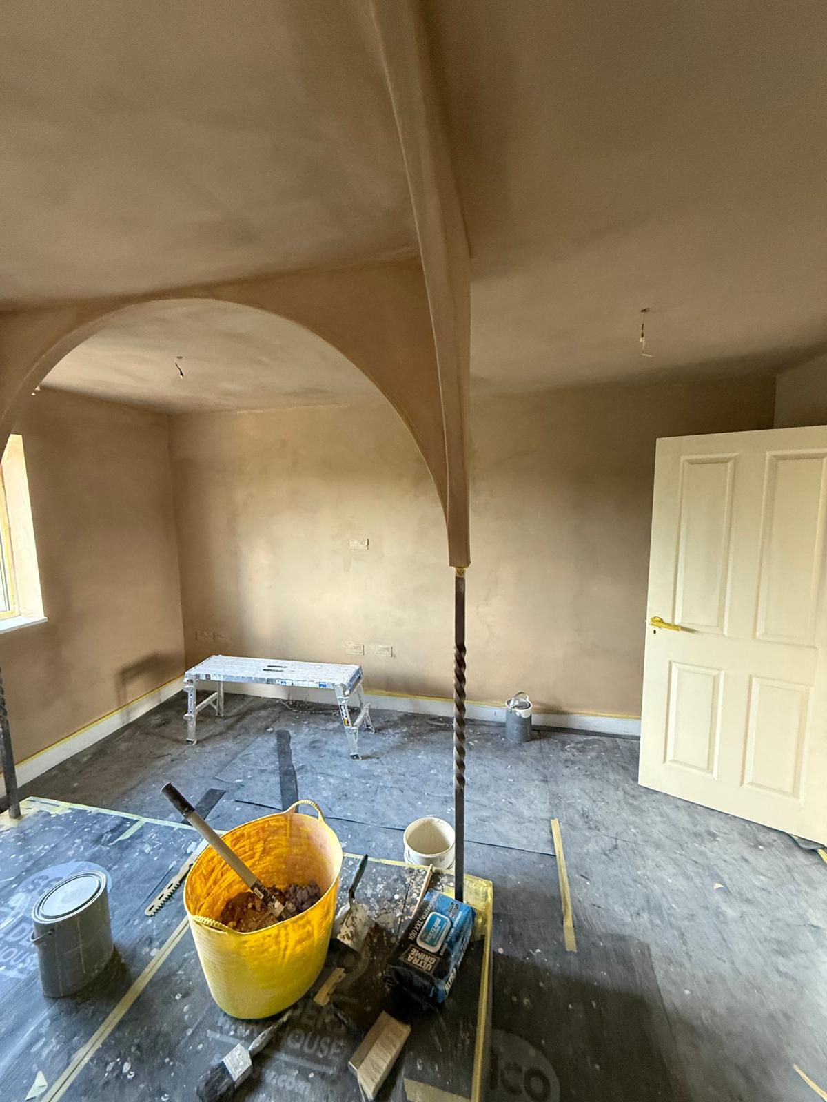 Hand-applied lime plaster forming a smooth vaulted arch in a refurbished room