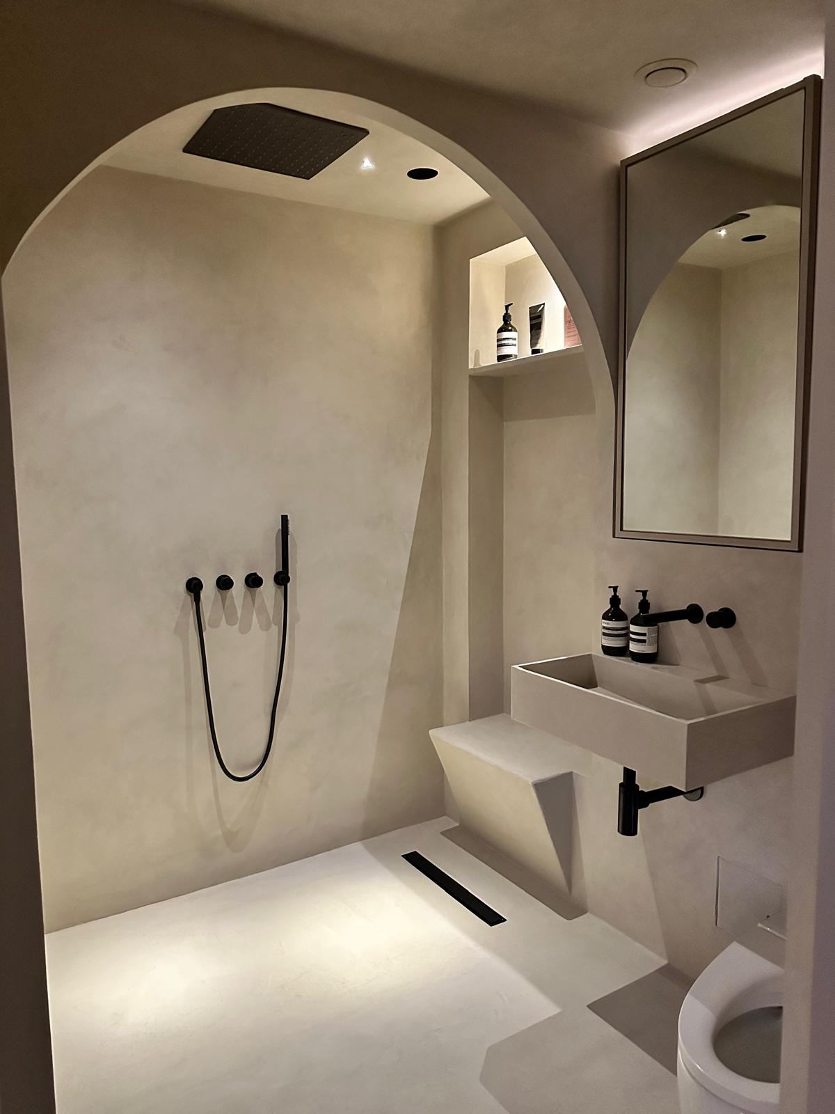 Finished tadelakt-style limewash wet room with an arched shower recess