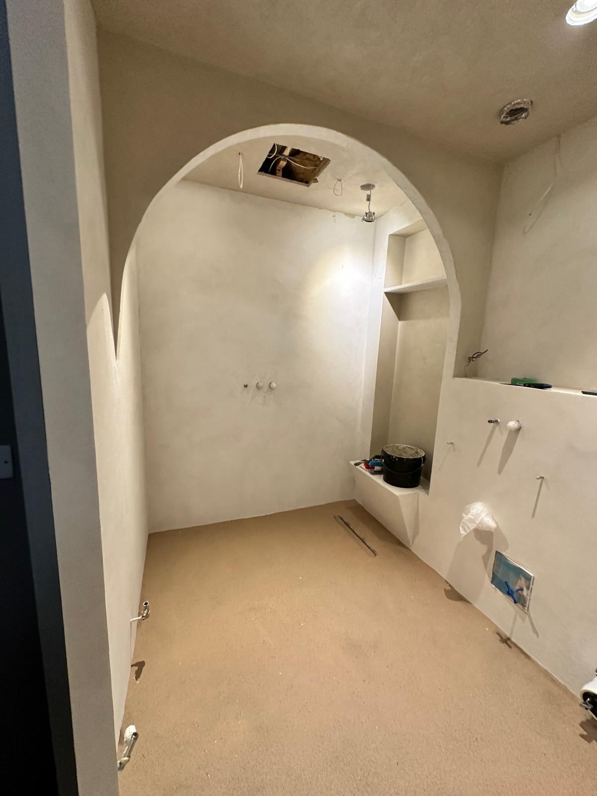 Room stripped back with a new lime-plastered arch being formed